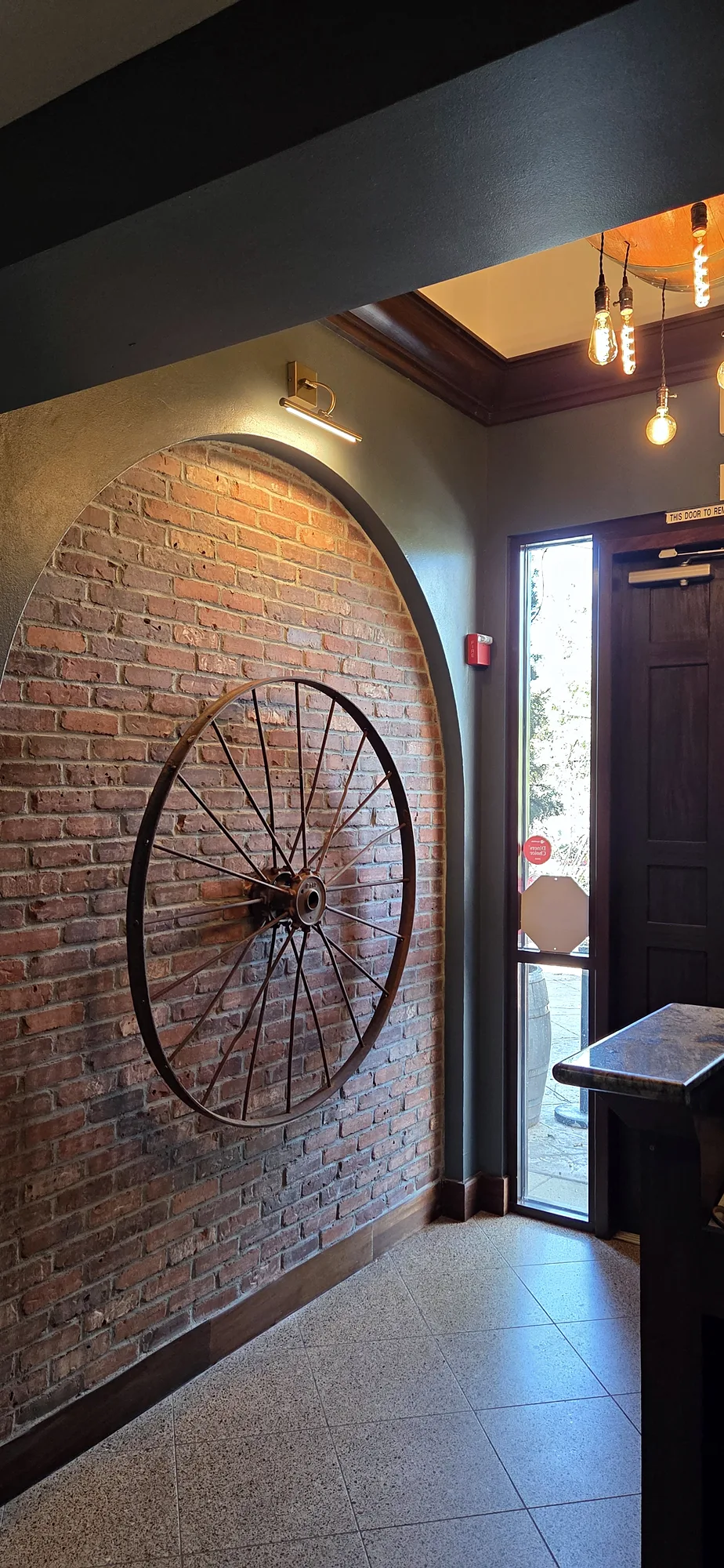 The brick entry arch at Mazzaro’s, with the iron wagon wheel