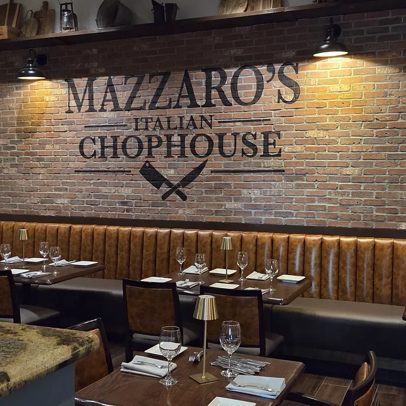 The Mazzaro’s Italian Chophouse brand wall painted on brick above the banquettes