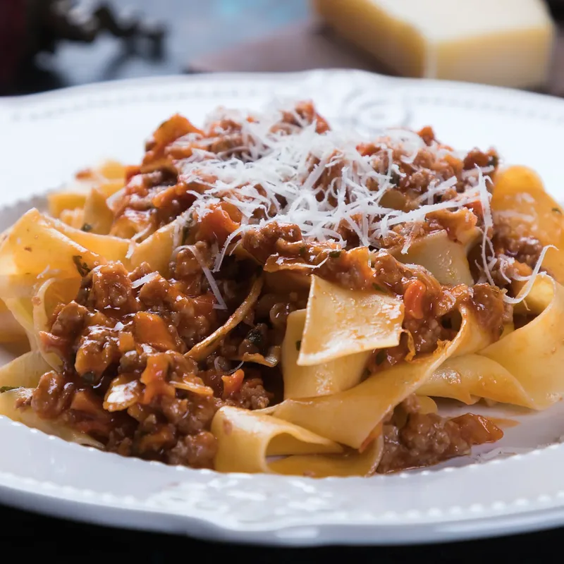 Pappardelle bolognese under grated Parmigiano