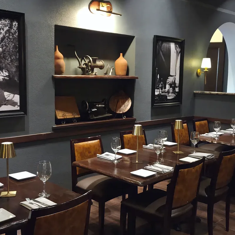 The bar end of the dining room, framed black-and-white photographs above the tables